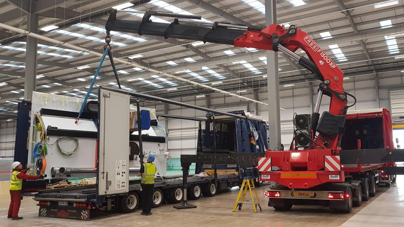 Red crane lifting a large piece of equipment